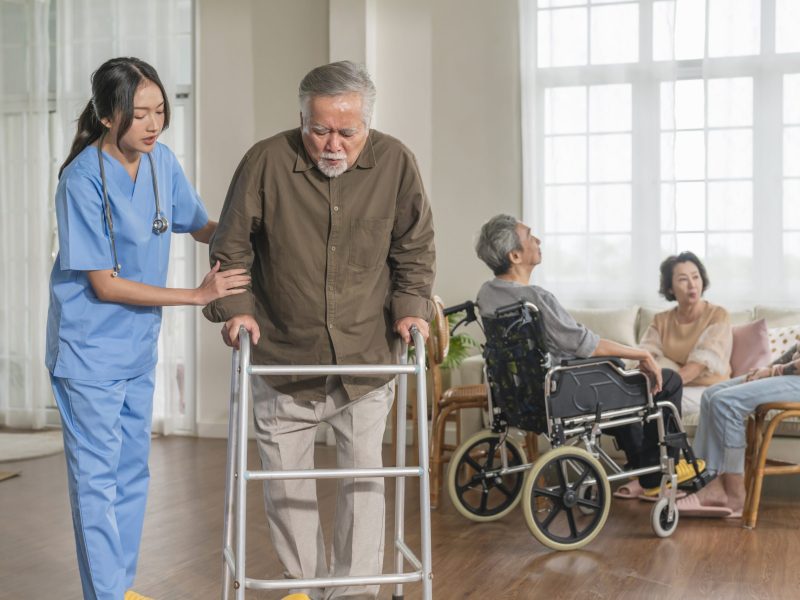 young asian female nurse care giver helping asian senior old man with mobility walker in living area of nursing home senior daycare center,Nurse take care elderly patient with cheerful concentrate